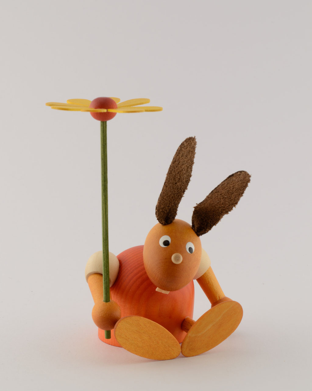Hase mit Blume sitzend