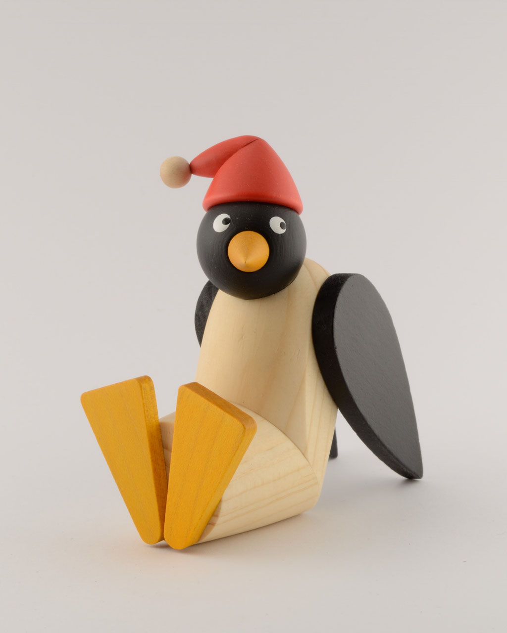 Pinguinfrau mit roter Mütze, sitzend